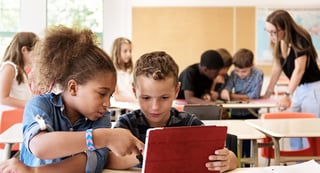 alunos em sala de aula olhando seus livros didáticos - Fluentize
